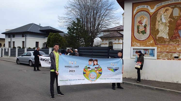 doi tineri afiseaza un banner