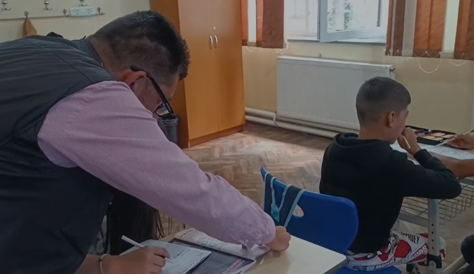 Învățătorul Florin Miroiu, alături de Ioana, o elevă de clasa a IV-a, care învață laolaltă cu colegi de-a II-a